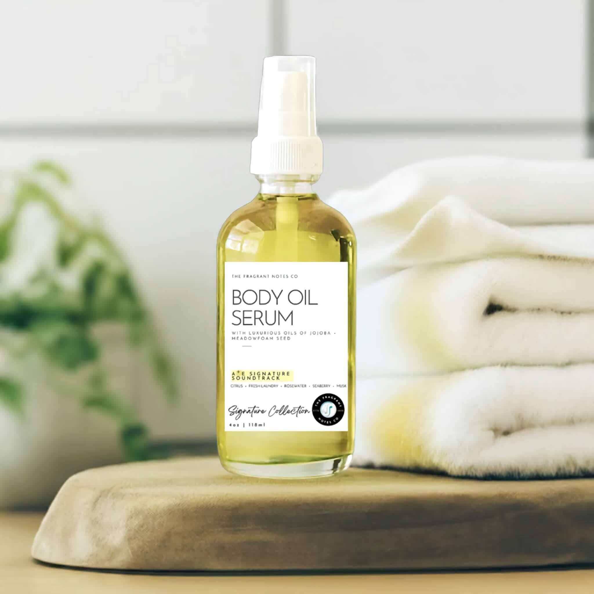 A+E Signature Soundtrack Body Oil Serum on a scandinavian bathroom wooden counter with white towels.