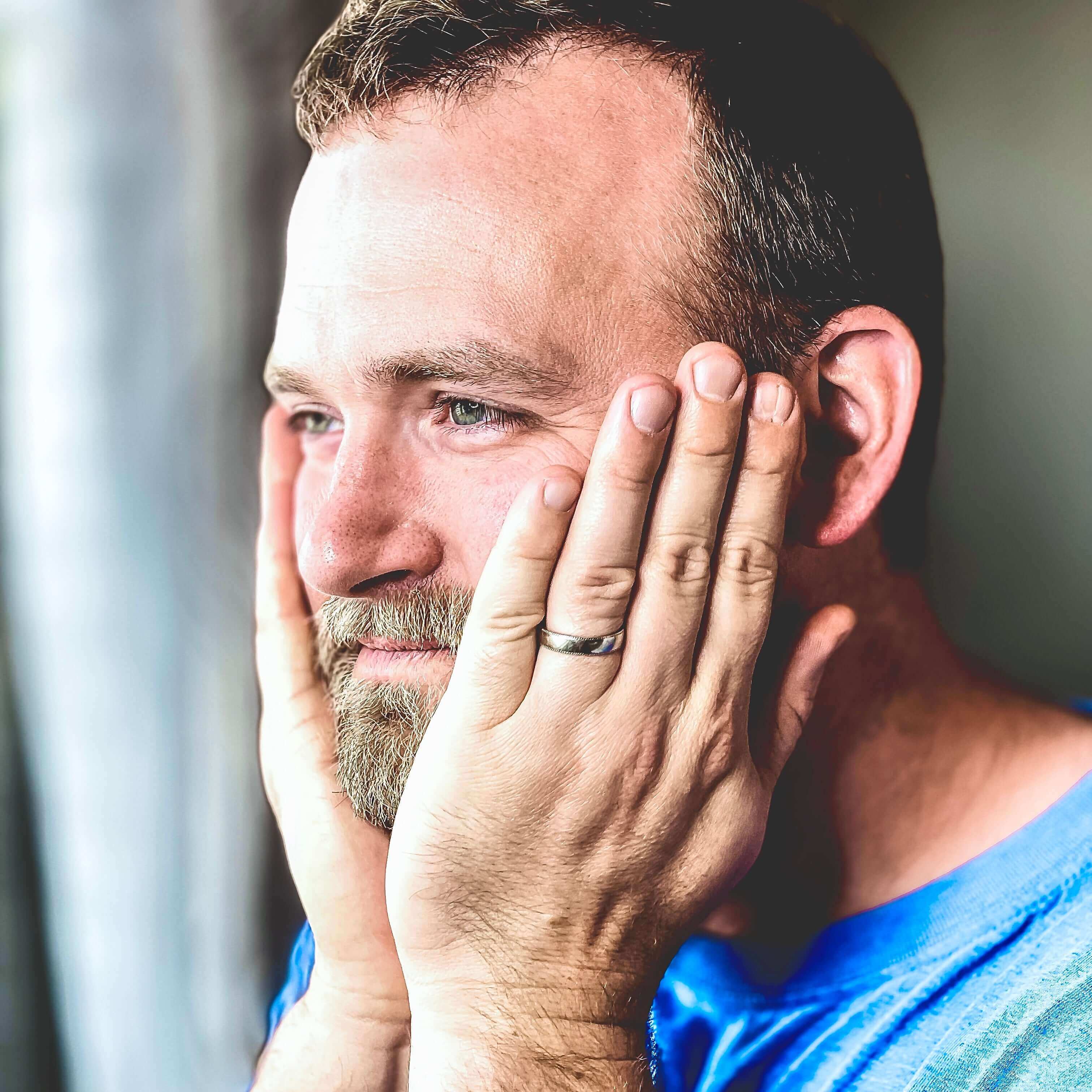 Man applying our Body Oil Serum on his beard.