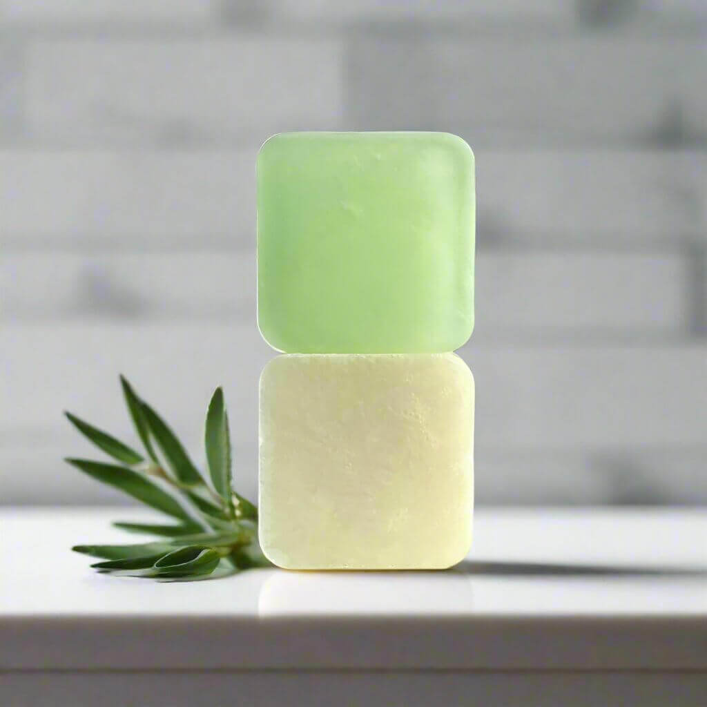 Clean Lines soap on white marble bathroom counter sitting next to a sprig of juniper leaves.