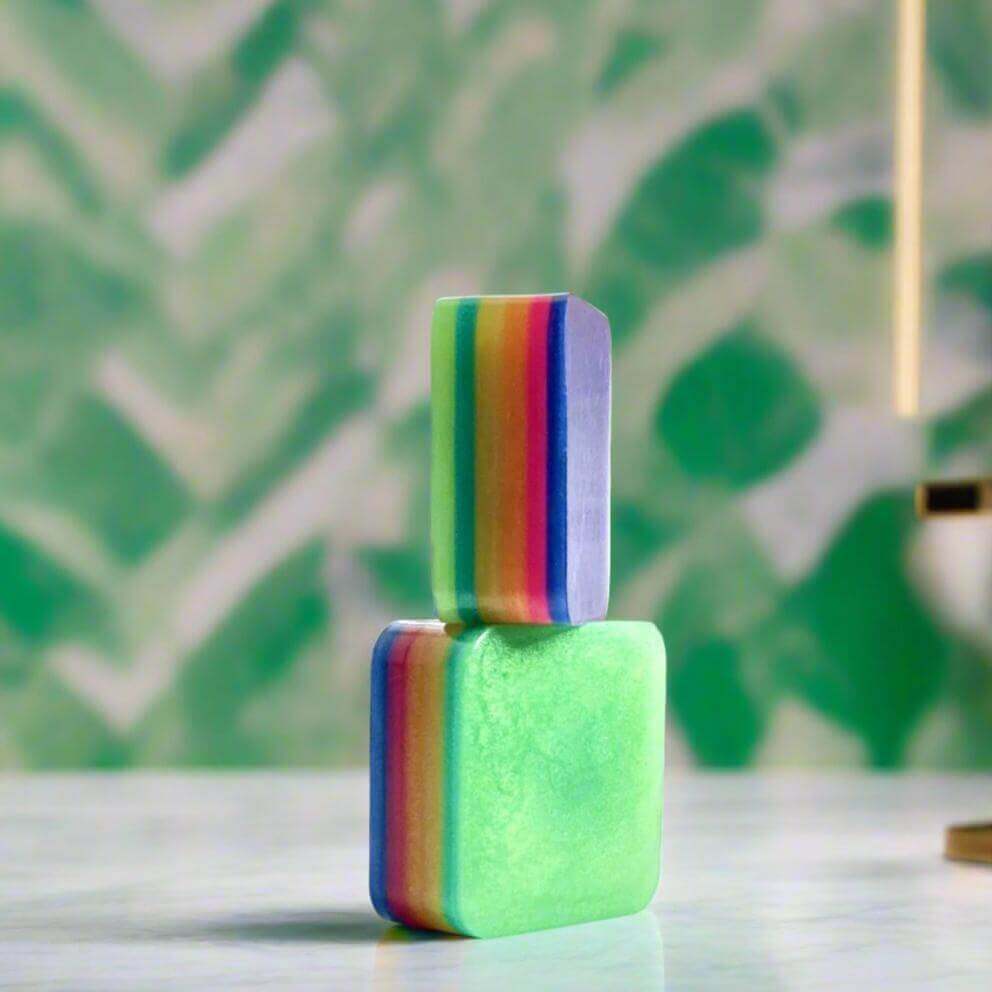 Groovy Rhythm soap on white bathroom countertop in front of green abstract wallpaper.