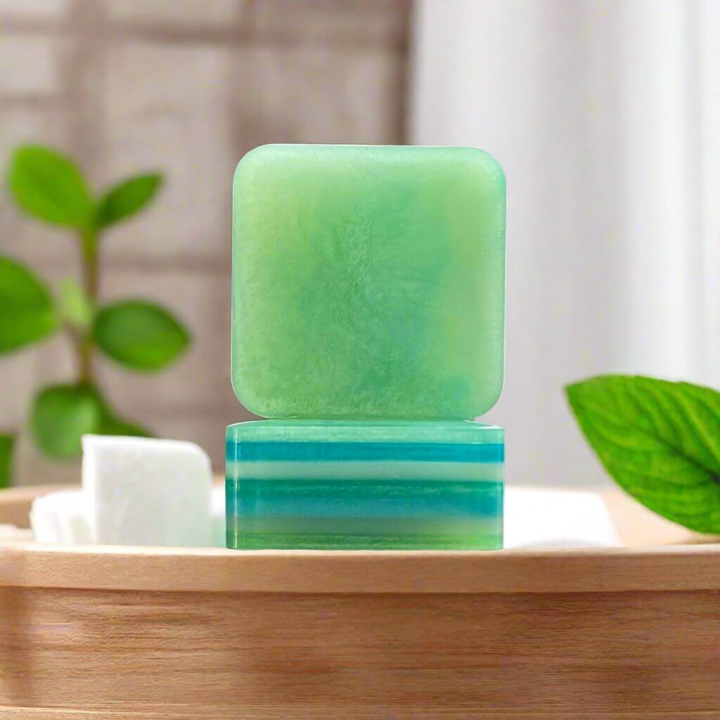 Vibrant Vibes soap bar sitting in a modern bathroom atop a wooden countertop, surrounded by mint leaves.